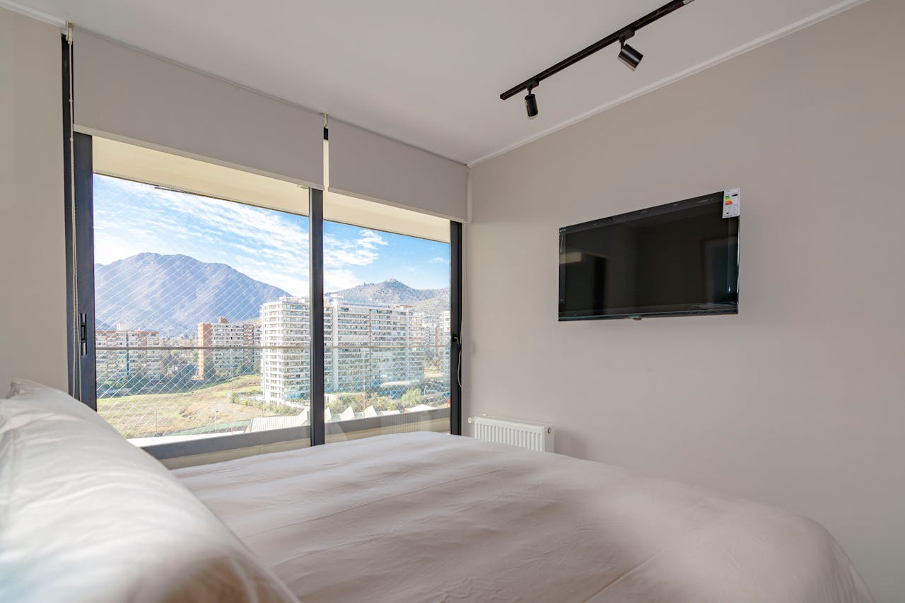 services-01 Cozy bedroom interior with a stunning mountain view and wall-mounted TV.