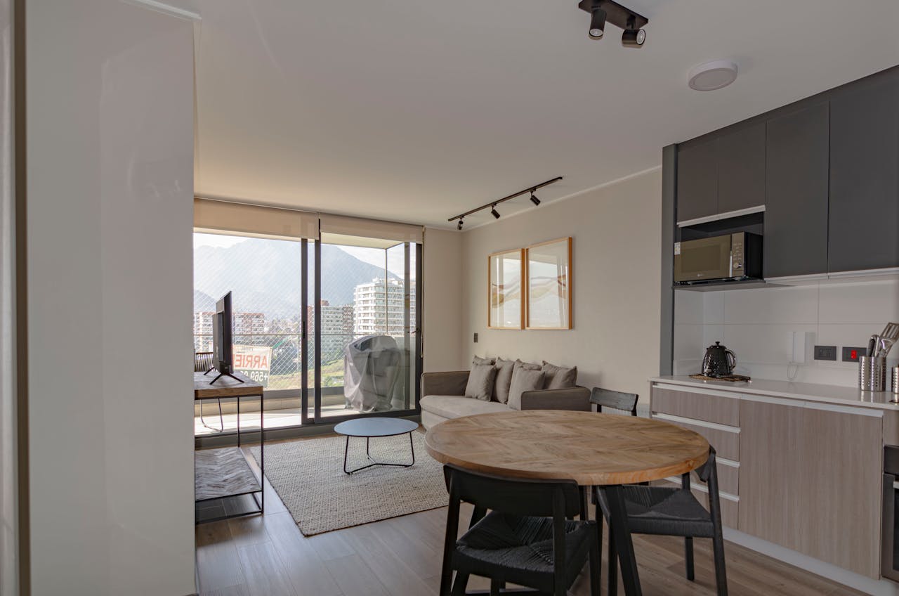 hero-img-01 Spacious modern living room with kitchen area overlooking city balcony view.